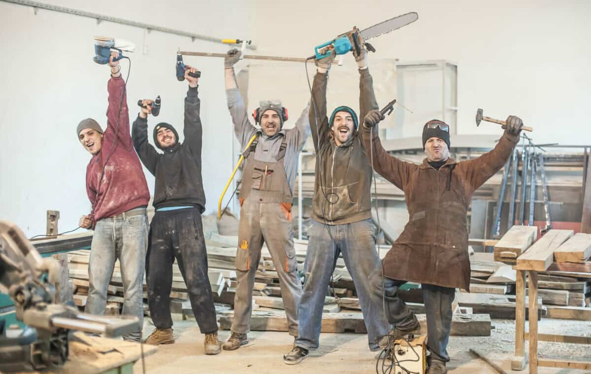 guruXOOX iStock-526294090 Workers posing with their tools in the workshop - Lykke og Humor på jobben håndverkere