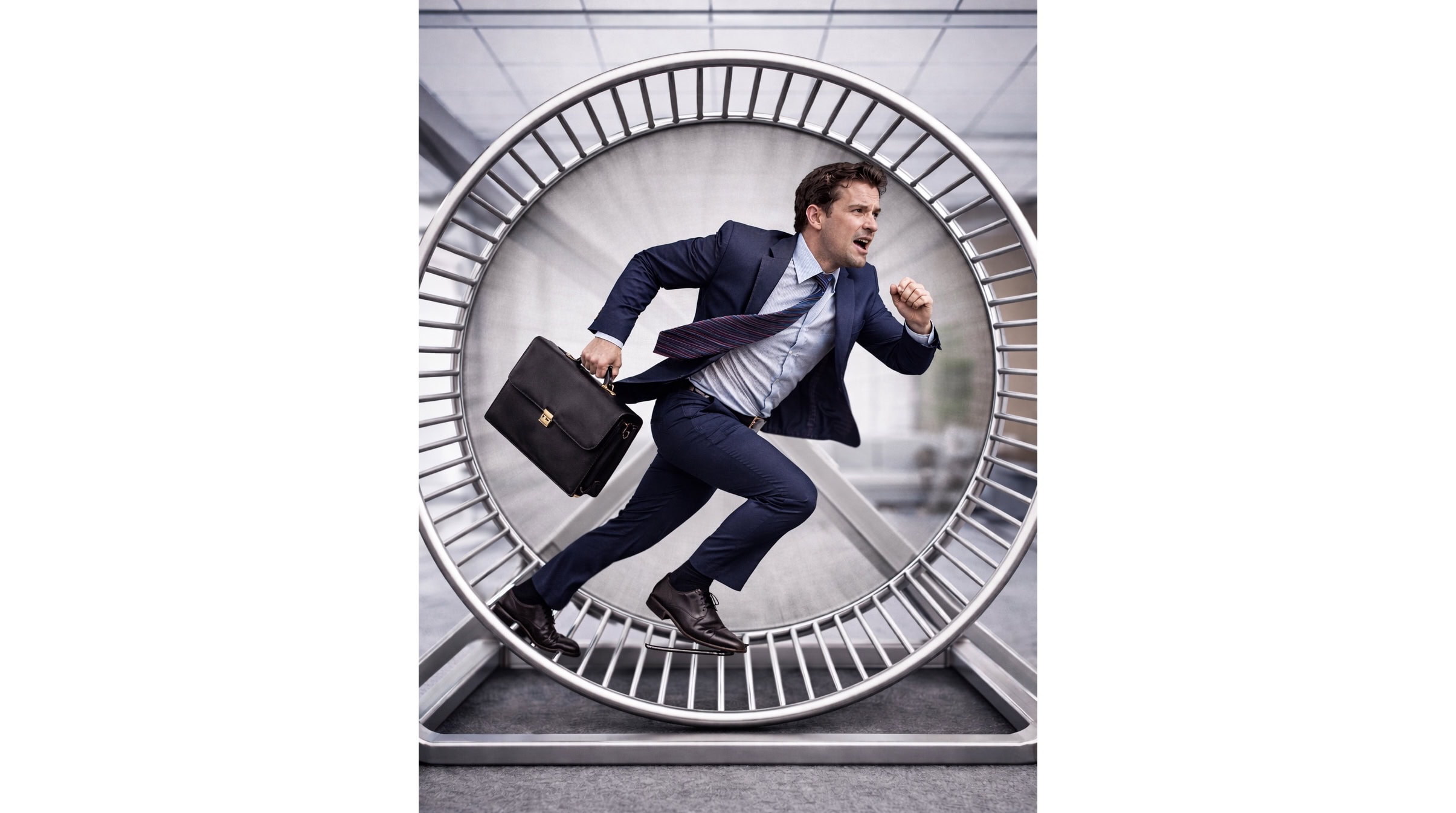 Forretningsmann i dress med stresskoffert i hamsterhjul