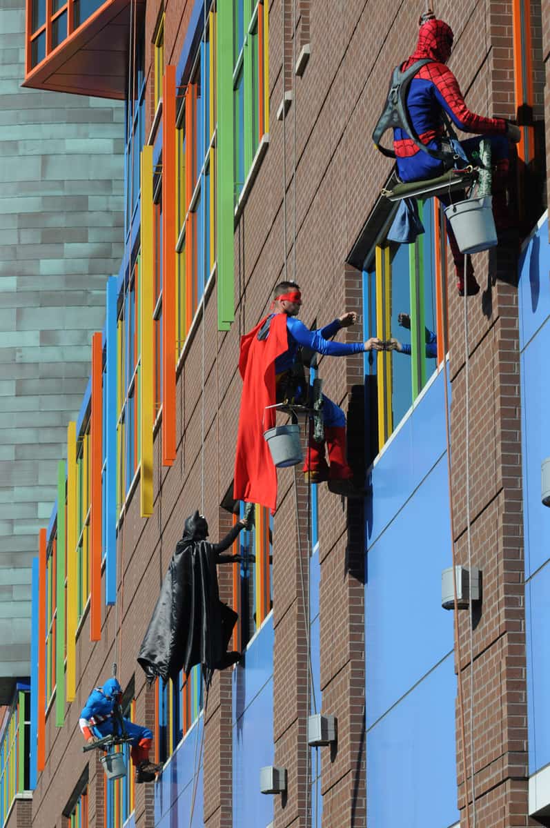 Superhelter vasker vinduer på barnesykehus